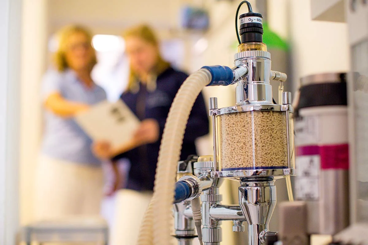 Bild von einem Narkosegerät im Vordergrund und zwei beratenden Tierärztinnen im Hintergrund